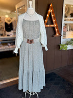 Olive green and white floral maxi dress styled with a cream open-knit cardigan and cream and brown waist belt for a layered transitional look at Ardor Boutique.