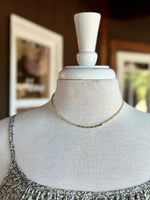 Neutral and gold beaded necklace with petite beads and gold-tone accents displayed on a mannequin at Ardor Boutique.