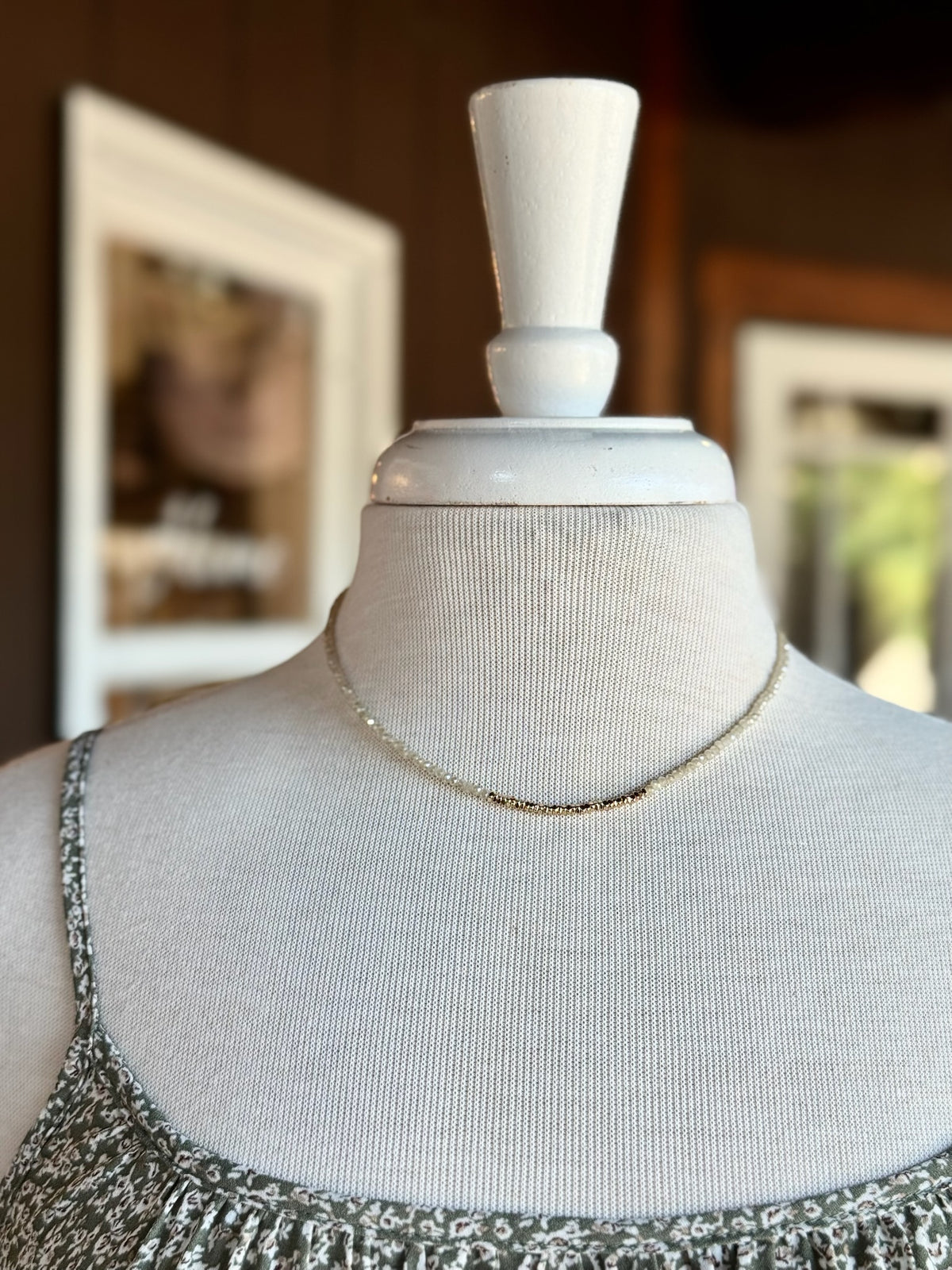 Neutral and gold beaded necklace with petite beads and gold-tone accents displayed on a mannequin at Ardor Boutique.