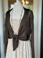 Brown lightweight cardigan styled tied at the waist over a neutral floral dress at Ardor Boutique.