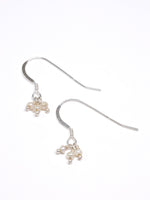 Silver earrings with small pearls on a white background