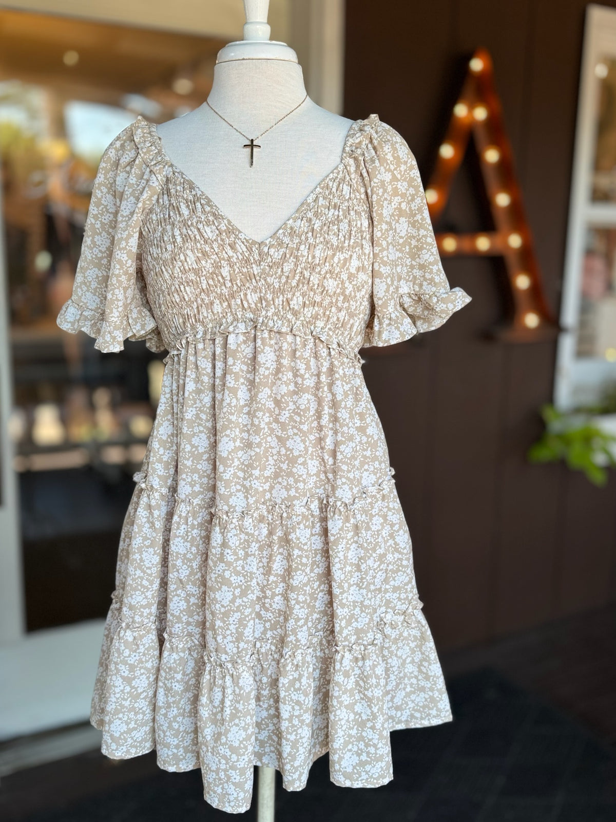 Gold-plated curved cross necklace with a delicate gold chain and slender cross pendant at Ardor Boutique.