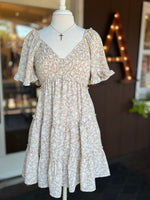 Beige and white floral dress with V-neckline, smocked bodice, flutter sleeves and tiered skirt at Ardor Boutique.