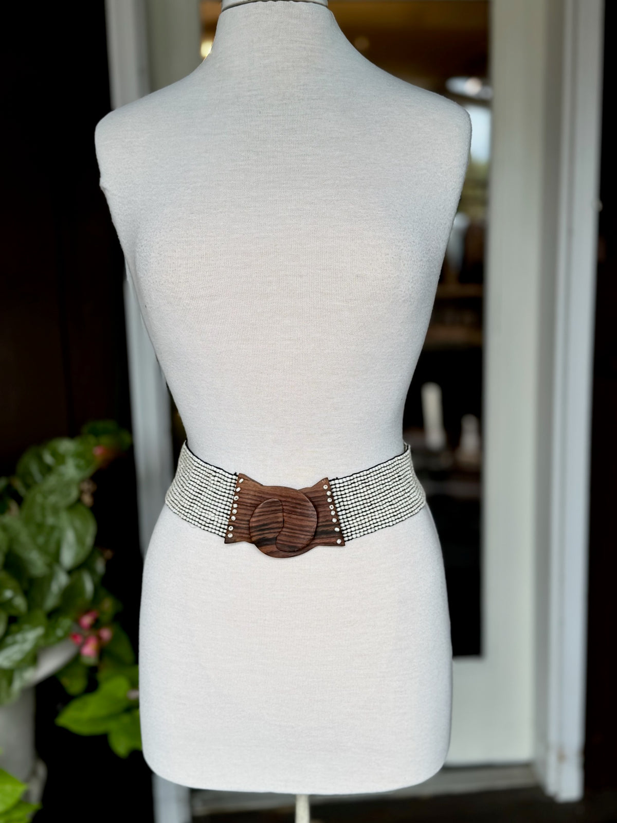 Ivory multi-row beaded stretch waist belt with natural brown wood-look statement buckle at Ardor Boutique.