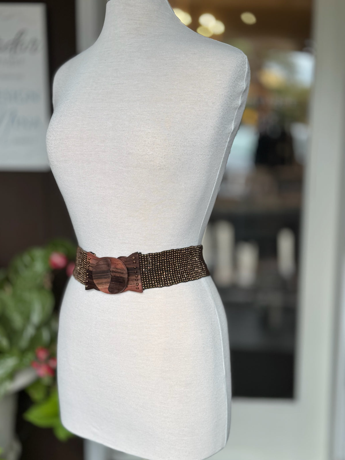 Brown beaded stretch waist belt with oversized wood-look buckle displayed on mannequin at Ardor Boutique.