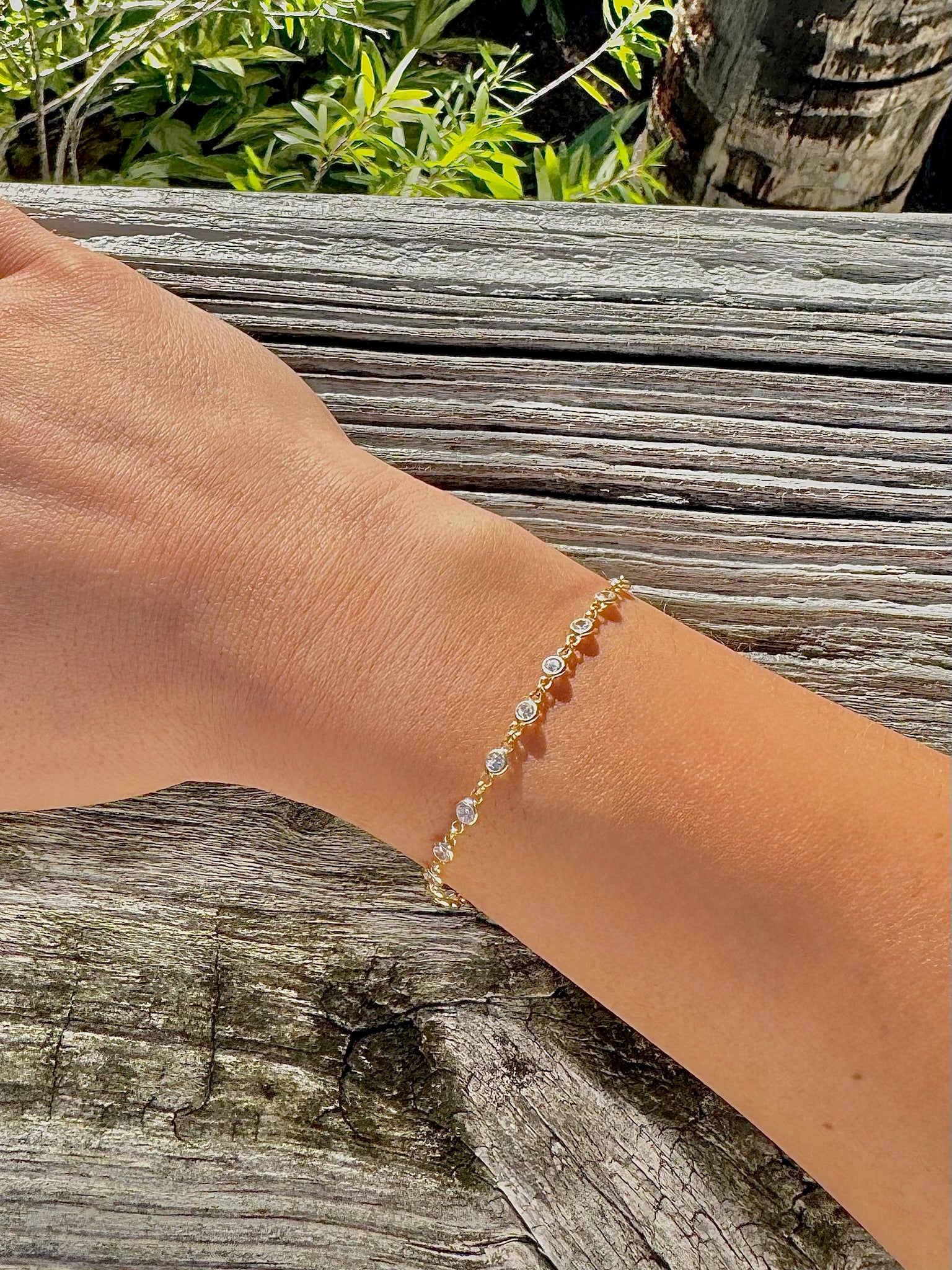 Gold bracelet on a wrist with a natural background