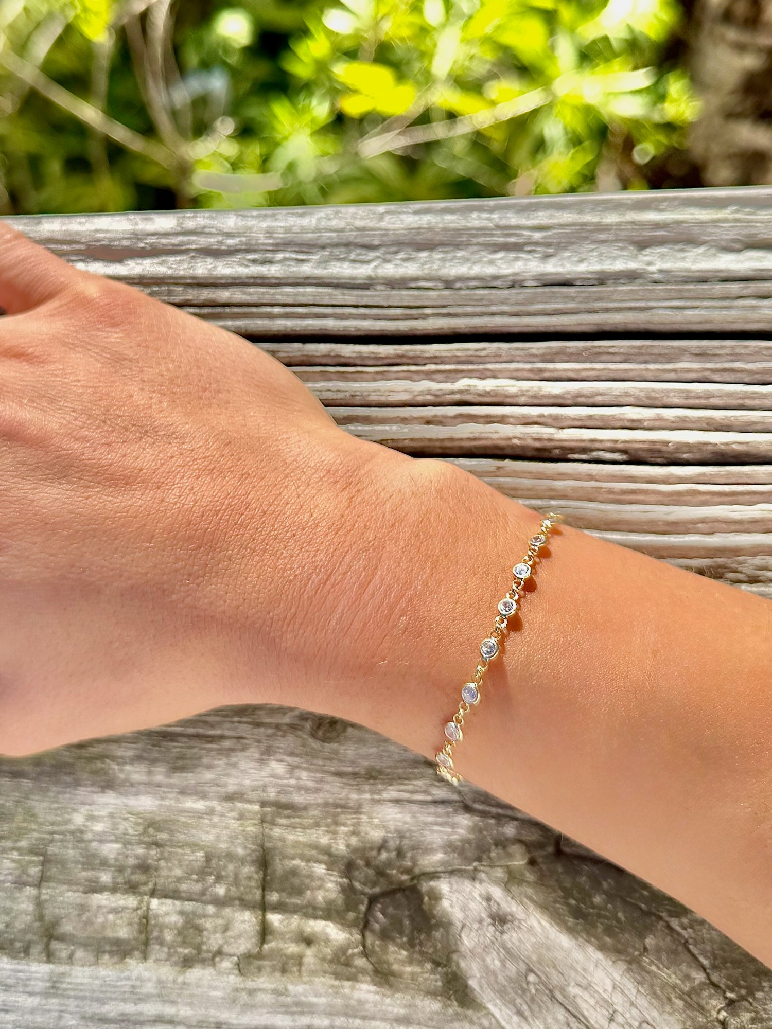 Hand wearing a bracelet with a natural background