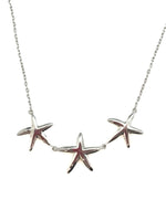 sterling silver necklace with three polished starfish details on a fine chain, product photo on white background.