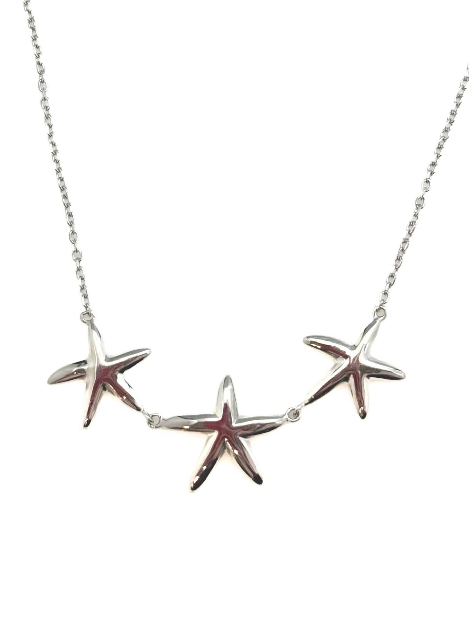 sterling silver necklace with three polished starfish details on a fine chain, product photo on white background.