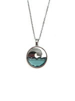 Necklace with a circular pendant featuring an ocean wave design on a white background