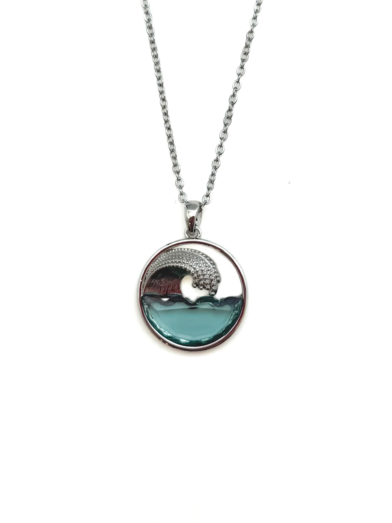 Necklace with a circular pendant featuring an ocean wave design on a white background