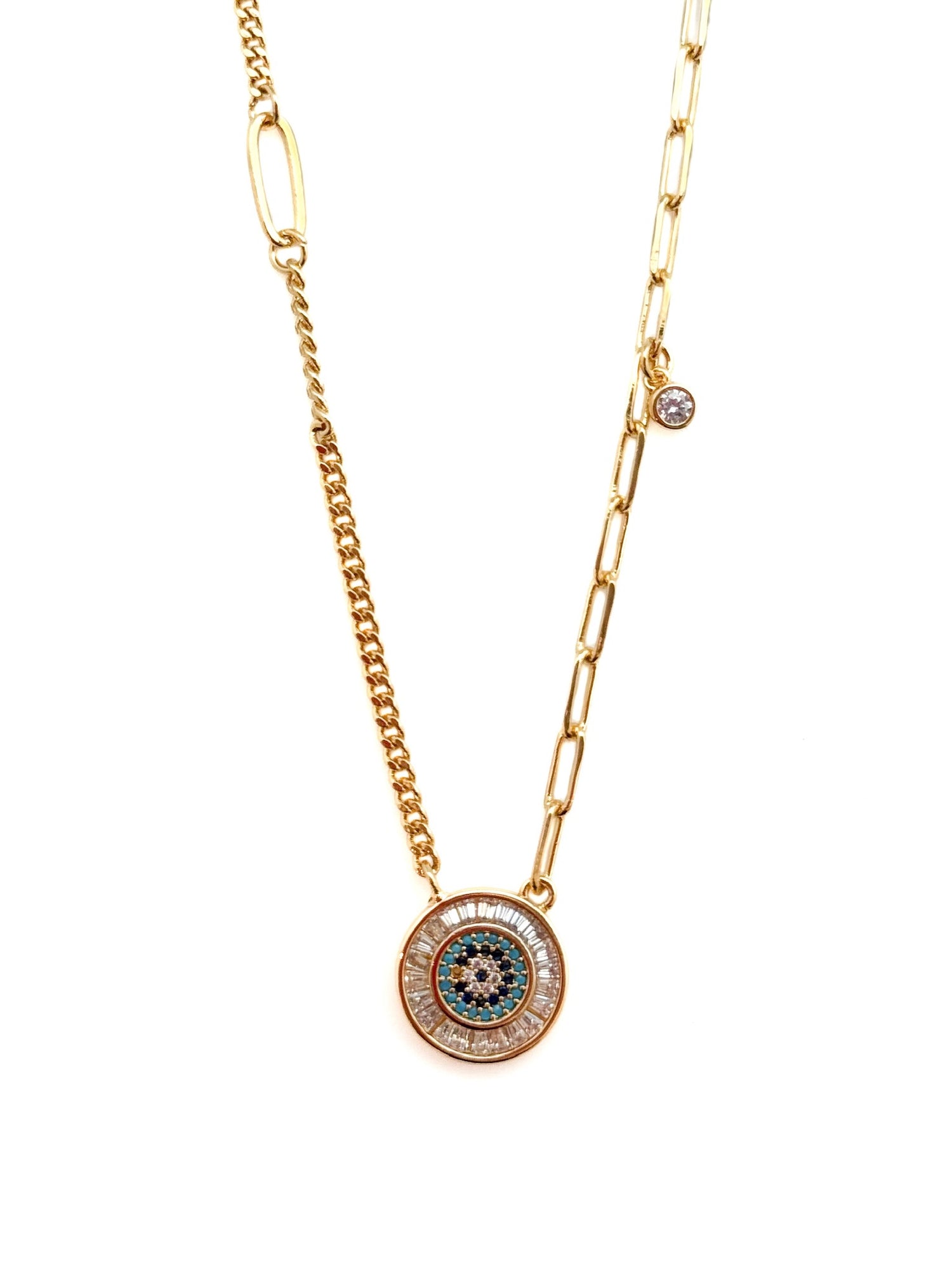 Gold necklace with a circular pendant on a white background