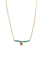 Ava Apatite Stainless Steel Necklace with gold-toned stainless steel chain, blue apatite bead bar, and crystal charm on white background.