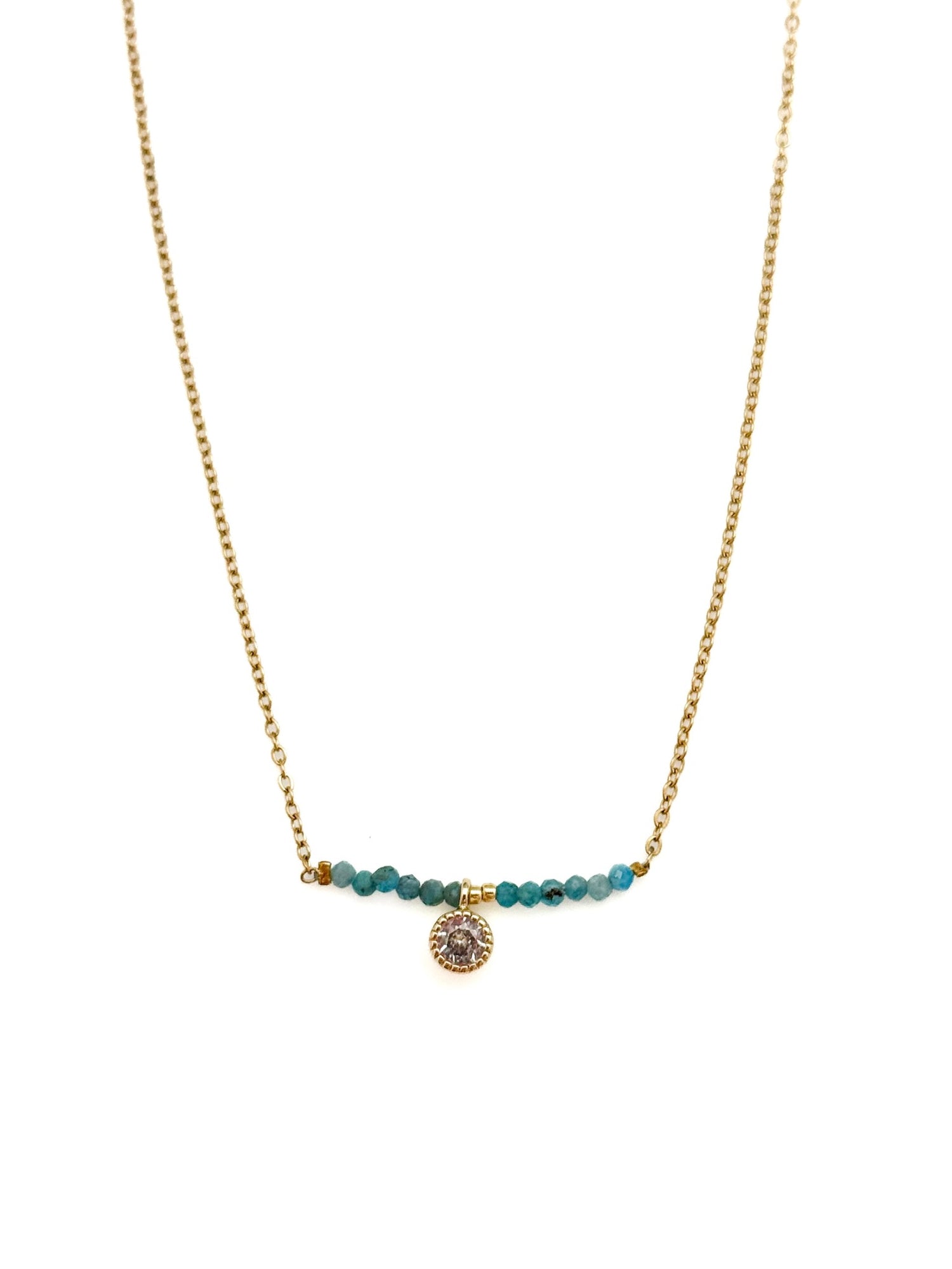 Ava Apatite Stainless Steel Necklace with gold-toned stainless steel chain, blue apatite bead bar, and crystal charm on white background.
