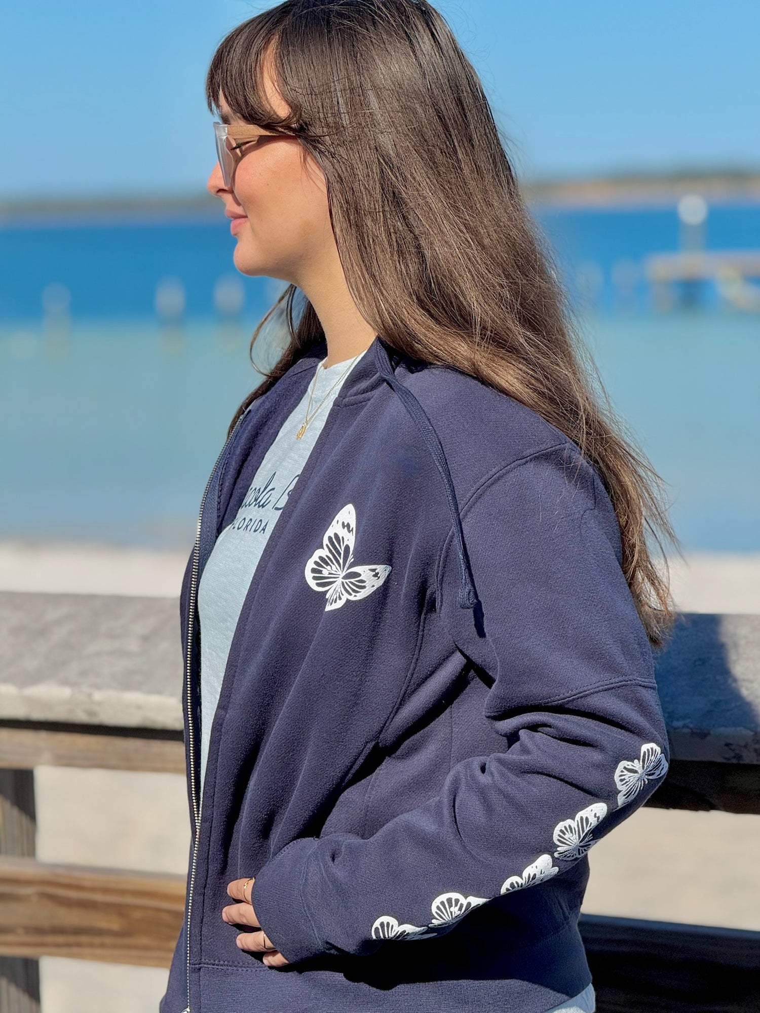 Women’s butterfly Zip-up hoodie with chest butterfly graphic, butterfly sleeve design, drawstring hood and ribbed trim at Ardor Boutique.