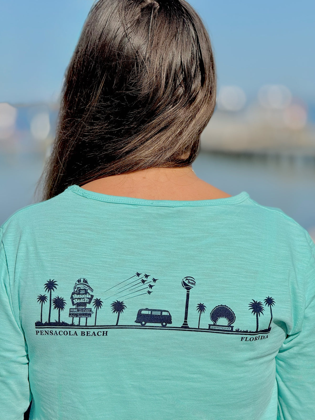 Person wearing an aqua women's Pensacola Beach long sleeve tee