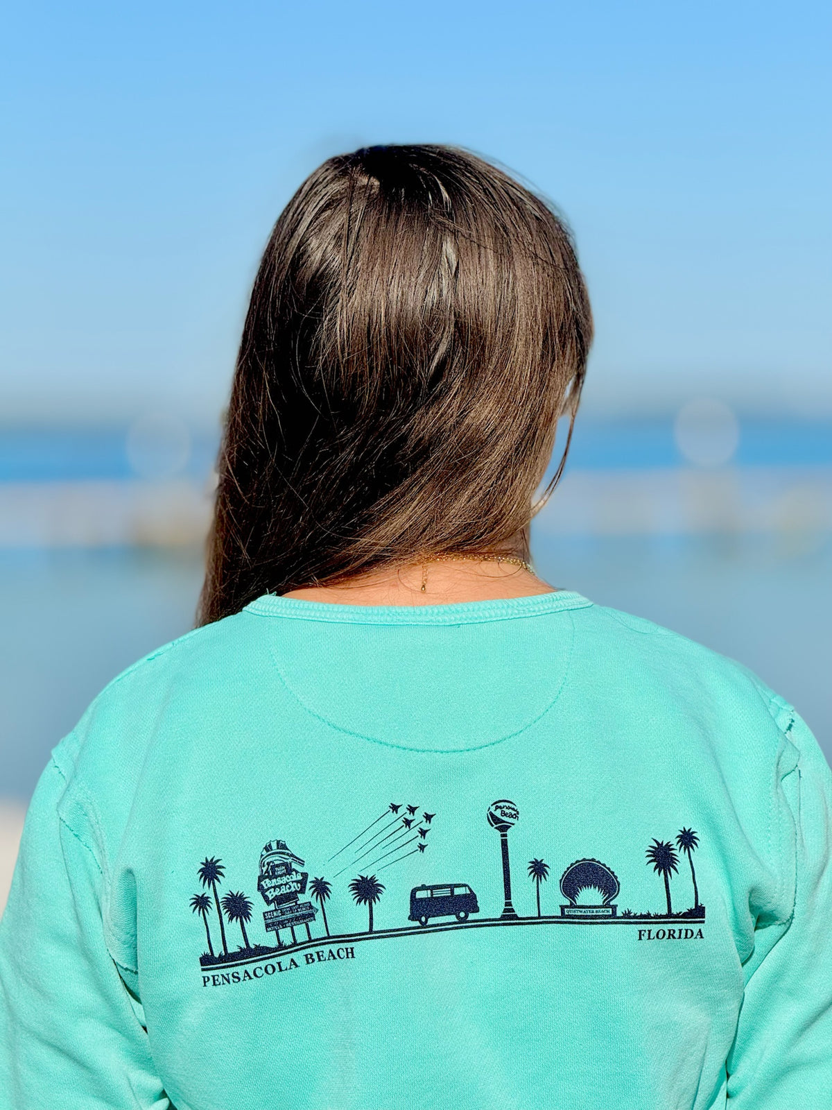 Pensacola Beach Icons Pocket Sweatshirt in aqua with front kangaroo pocket and Pensacola Beach Florida script graphic at Ardor Boutique.