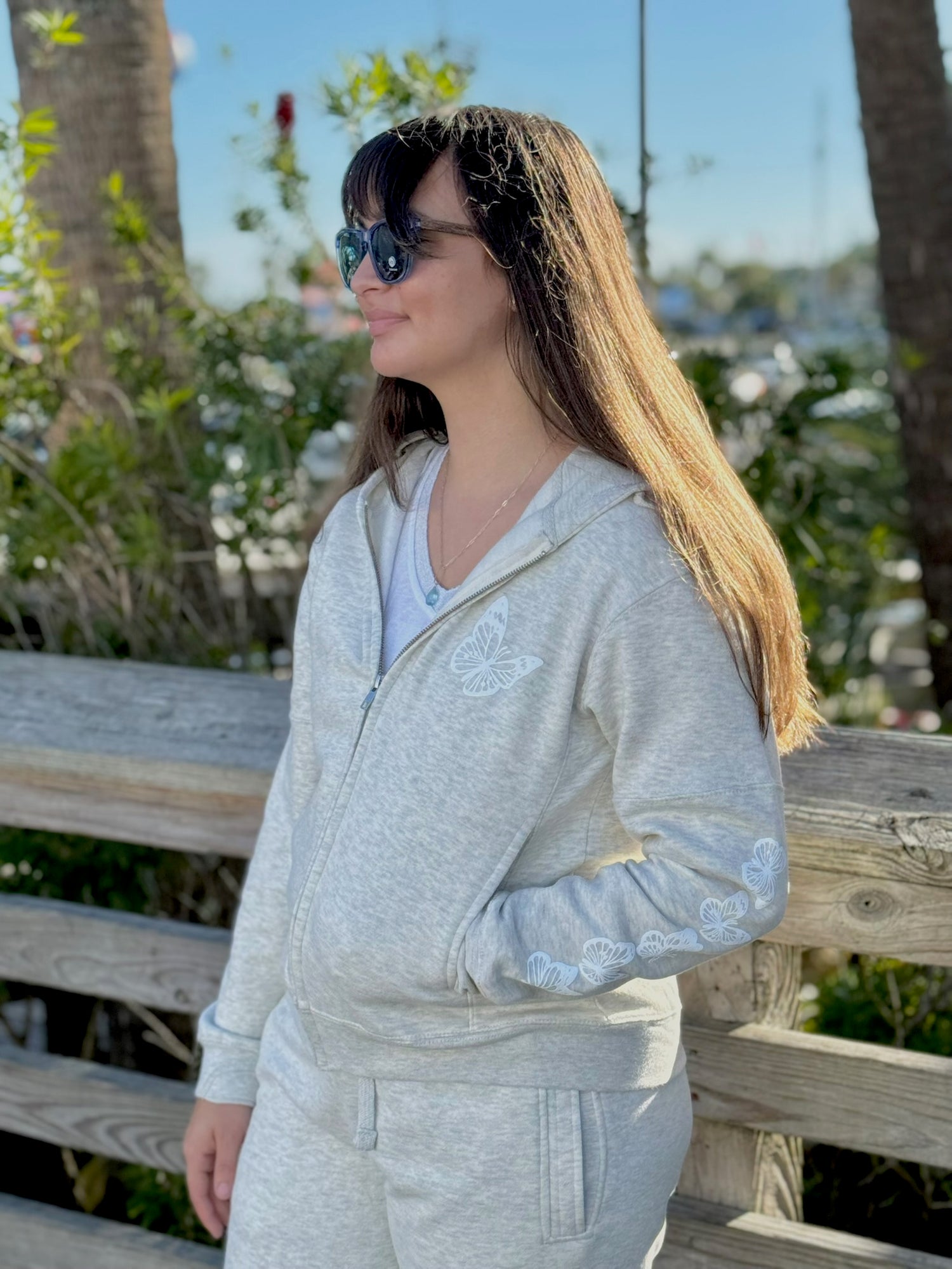 Women’s butterfly Zip-up hoodie with chest butterfly graphic, butterfly sleeve design, drawstring hood and ribbed trim at Ardor Boutique.