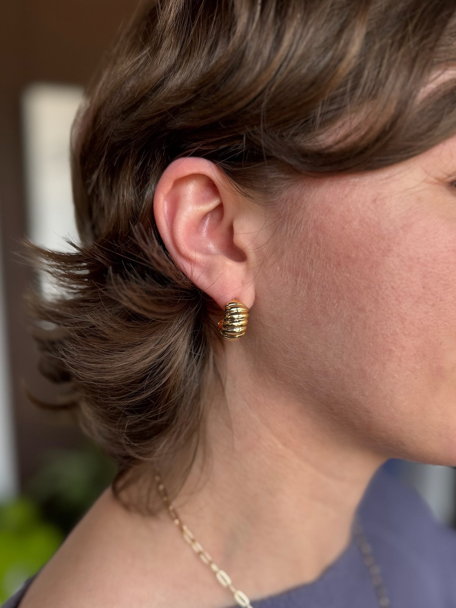 woman wearing chunky gold earring 