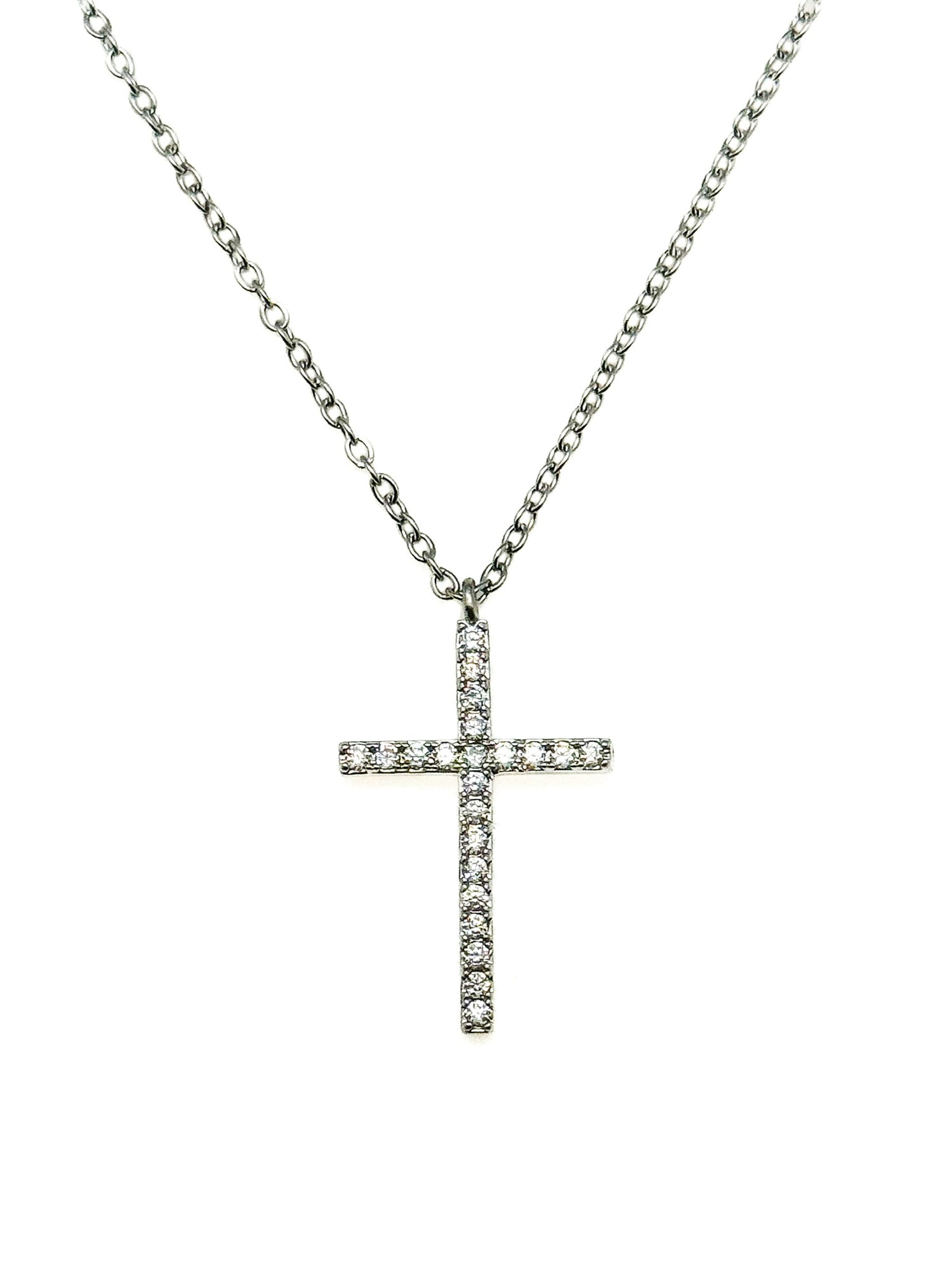 Pavé crystal cross pendant necklace on a silver chain against a white background