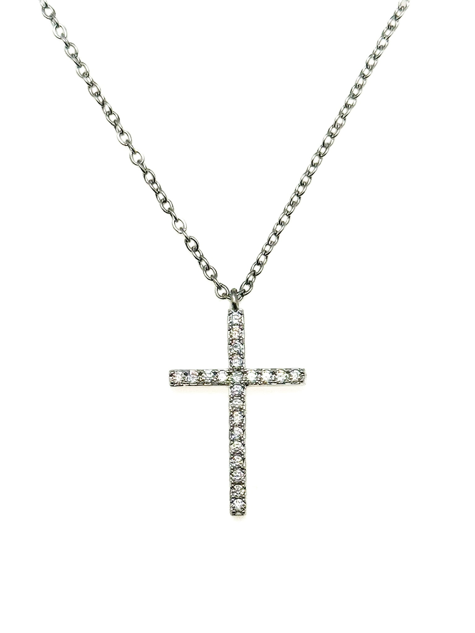 Pavé crystal cross pendant necklace on a silver chain against a white background