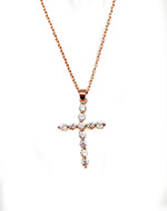Rose gold cross pendant necklace on a white background
