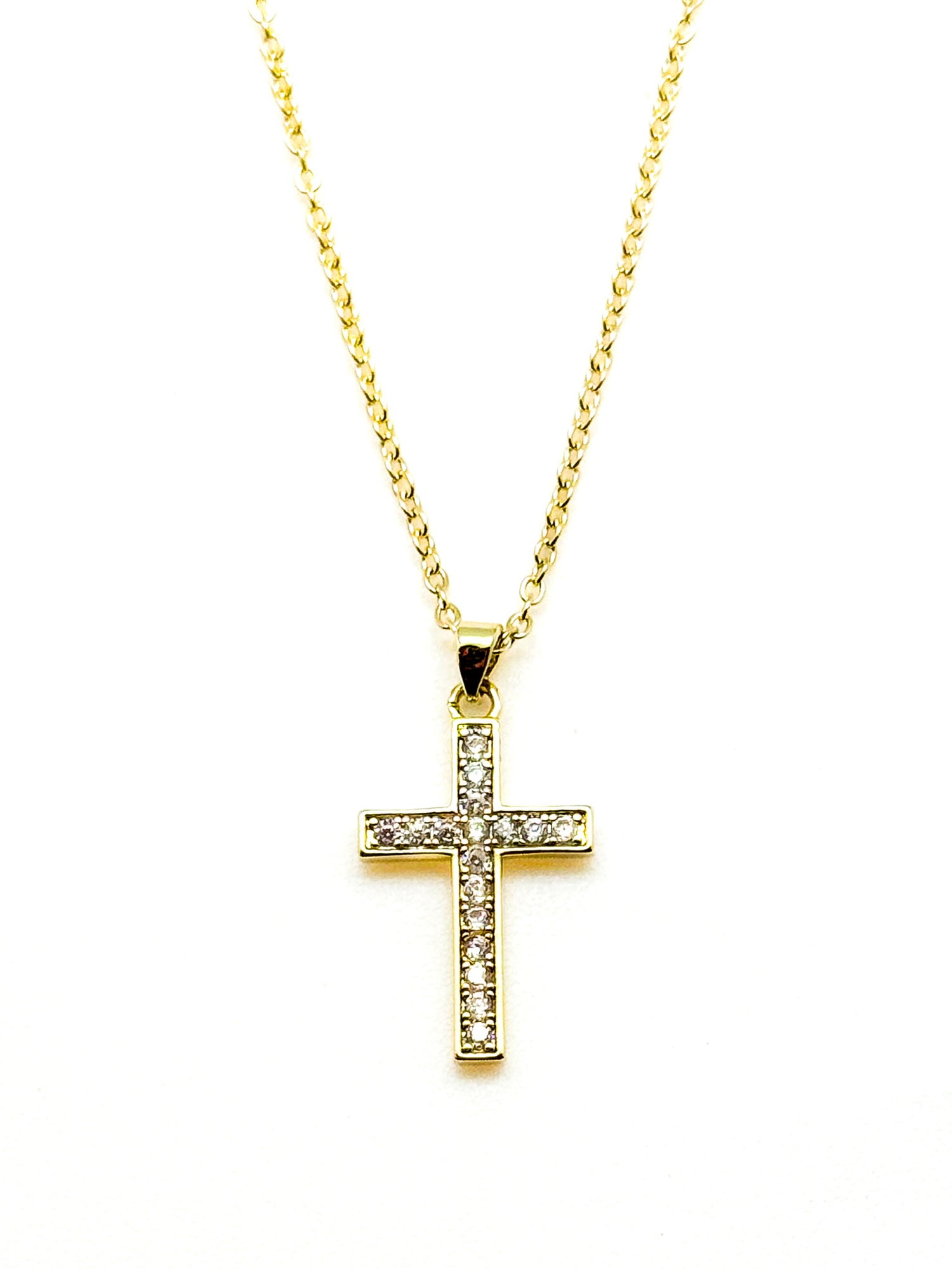 Gold cross necklace with diamonds on a white background