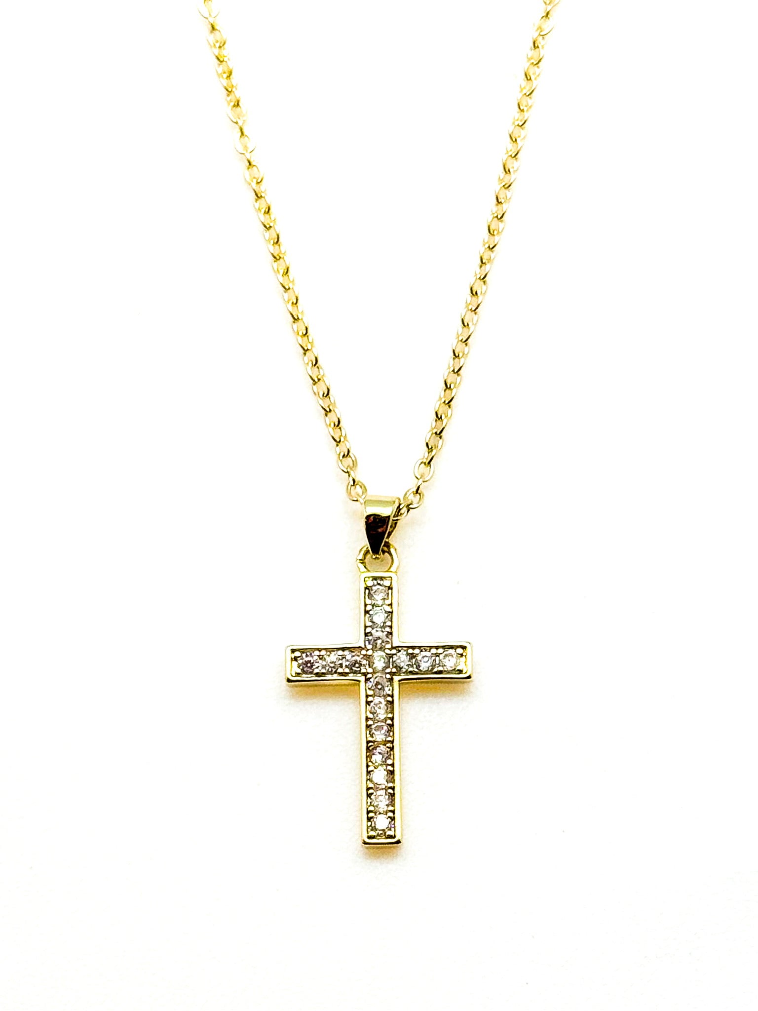 Gold cross necklace with diamonds on a white background