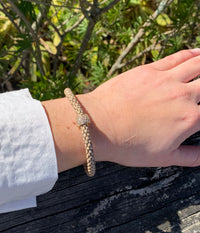 Scarlett taupe bracelet, tan interlocking chain with charm on model.
