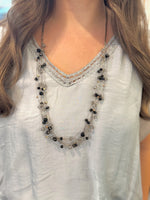 Necklace with black and clear beads on a white blouse