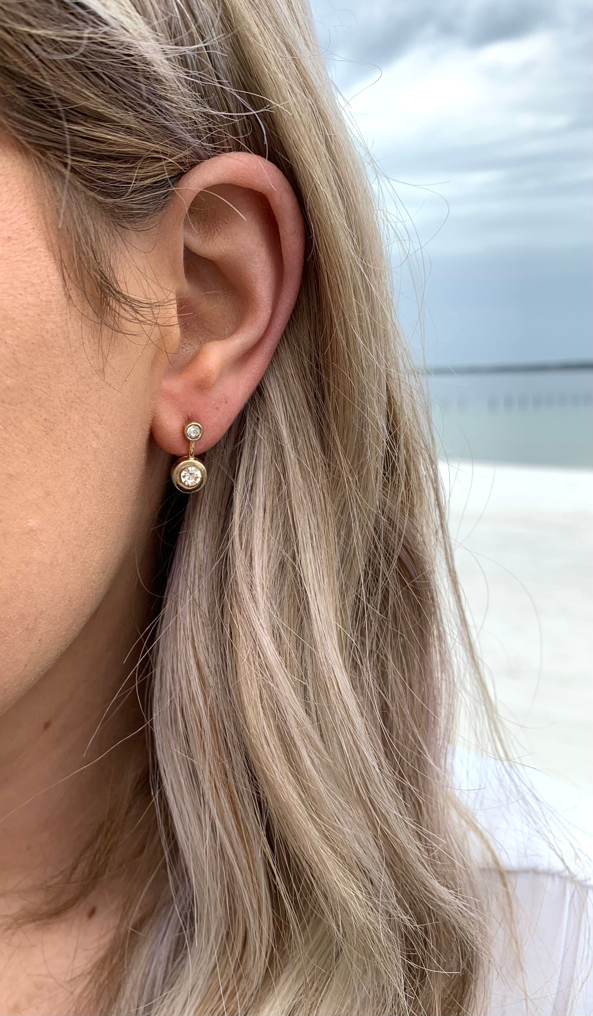 Karen stud earrings in gold with tiny crystals on ear