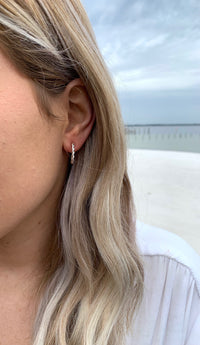 medium sized silver hoop earrings with twisted rope detail in model ear