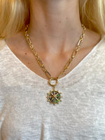 Nautical-style necklace featuring a gold chain and iridescent abalone shell compass pendant