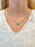 gold-toned necklace with scattered green and turquoise gemstone chips and a large central turquoise teardrop pendant