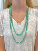 Evie Necklace with faceted aqua-green layered beads on models neck at Ardor Boutique.