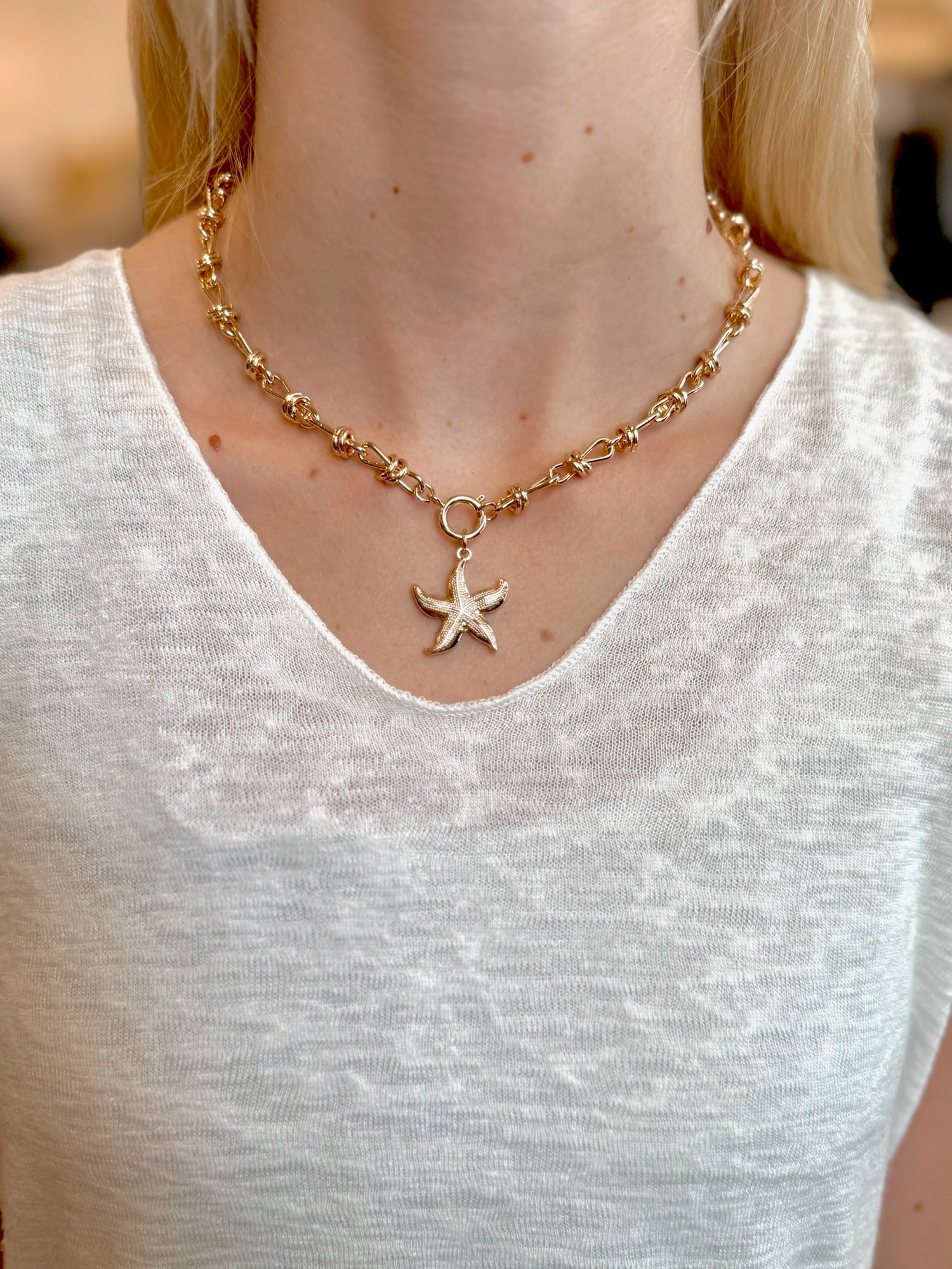 Lola Starfish Necklace in gold with textured pendant on model neck
