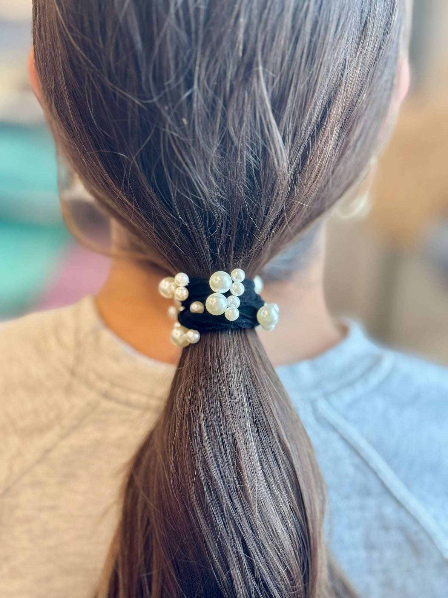 Pearl hair tie on a ponytail with a blurred background