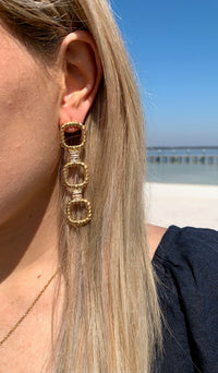 Arabella sparkly earrings in gold on model. 