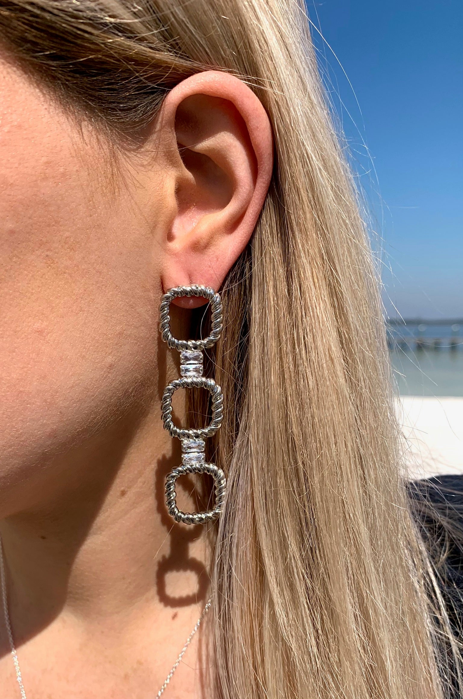 Arabella Sparkly earrings in silver on model. 