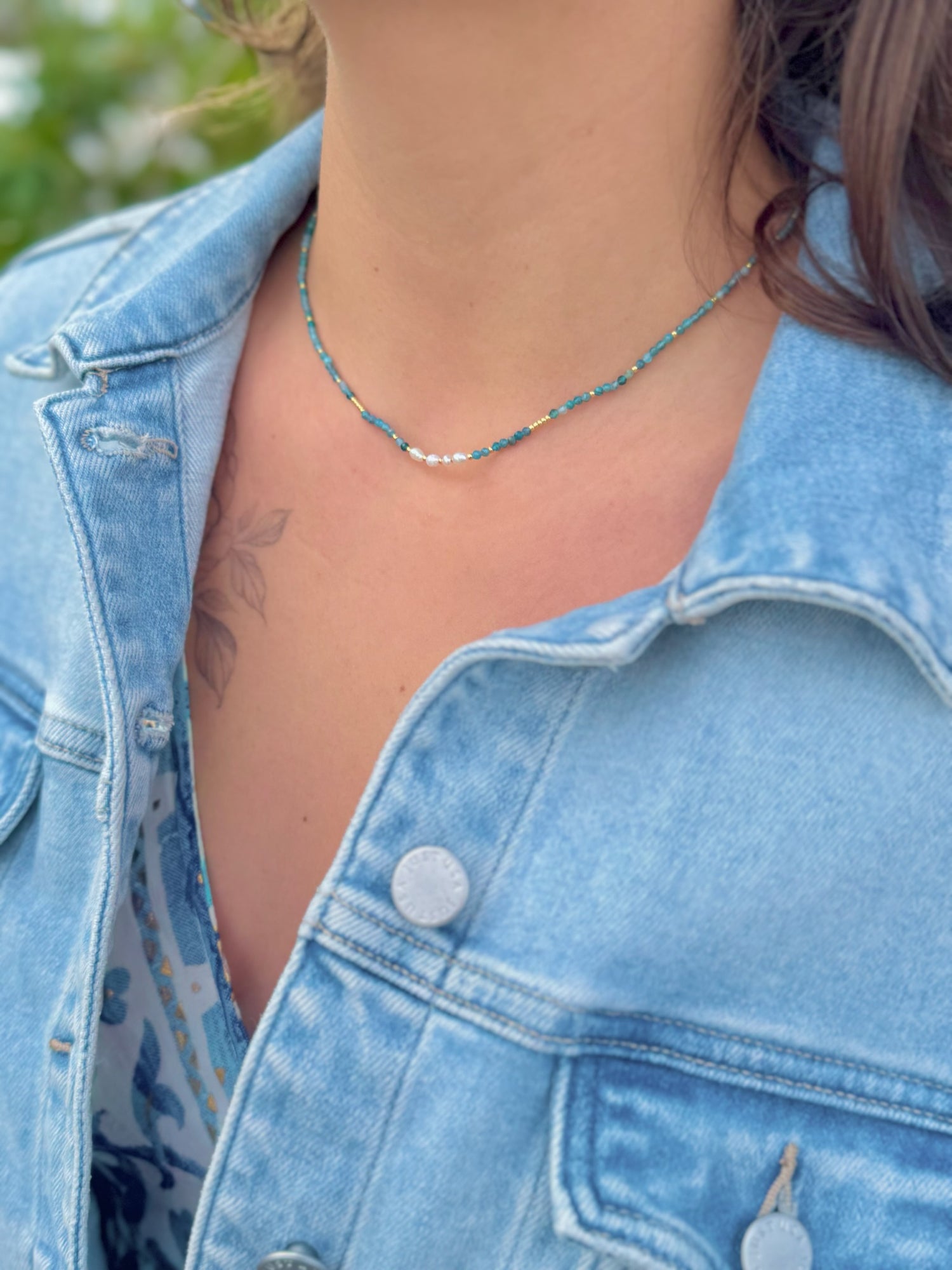 Model wearing Apatite Stainless Steel Necklace featuring sea-toned apatite beads with a freshwater pearl center detail.