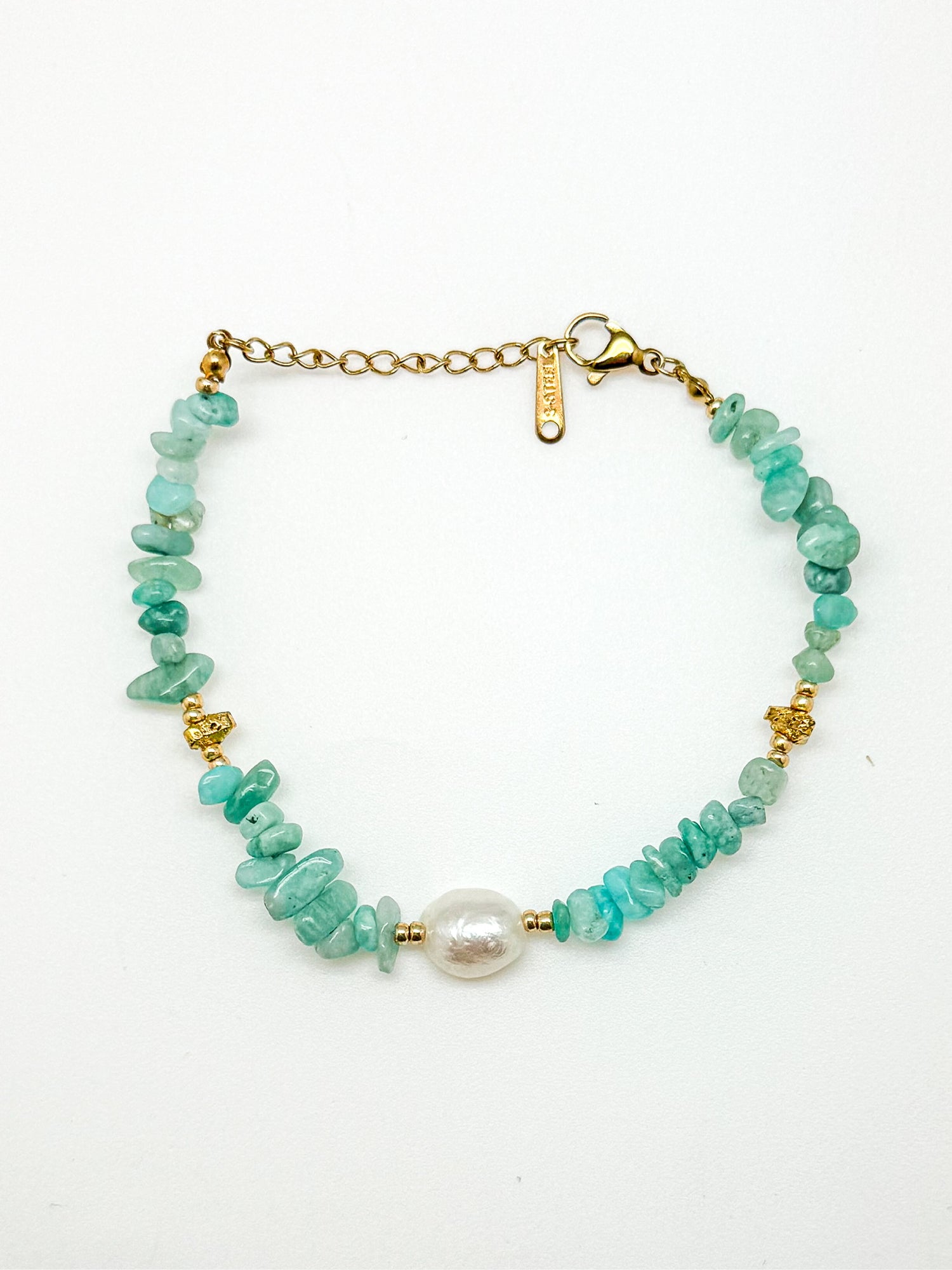 Bracelet with turquoise beads and a pearl on a white background