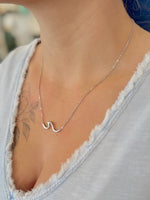 sterling silver wave pendant necklace worn with a V-neck top, showing length and fit.