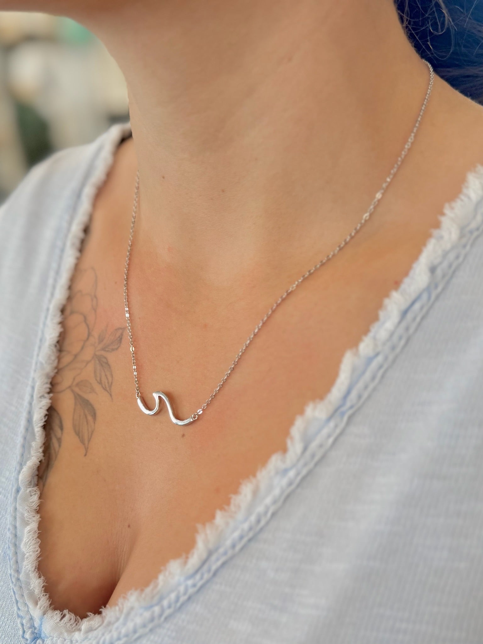 sterling silver wave pendant necklace worn with a V-neck top, showing length and fit.