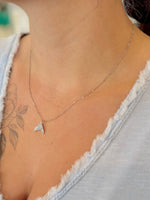 sparkly sterling silver dolphin tail necklace worn at the collarbone on an adjustable chain.