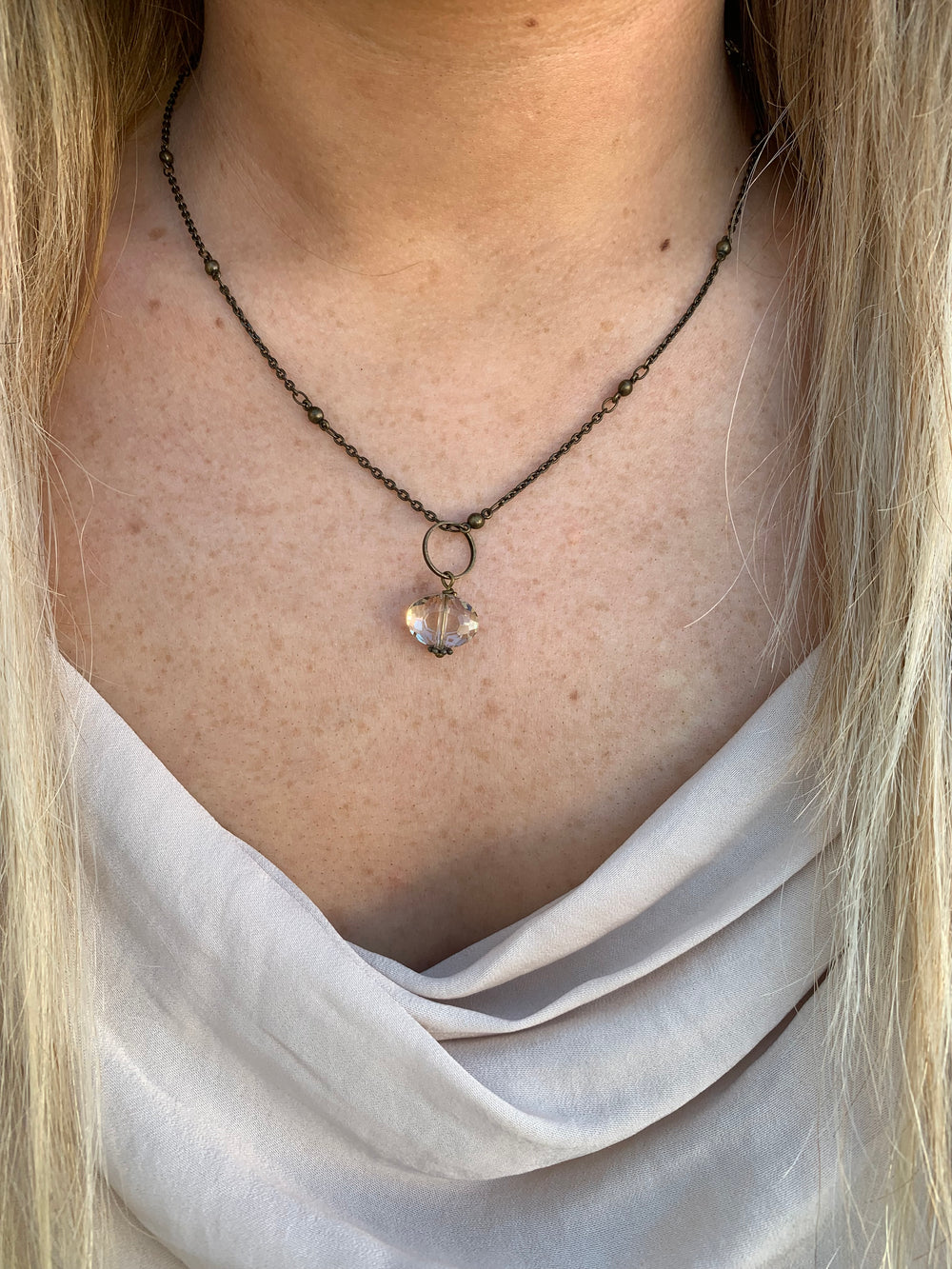 simple neural drop necklace in brass nickel free on model. 