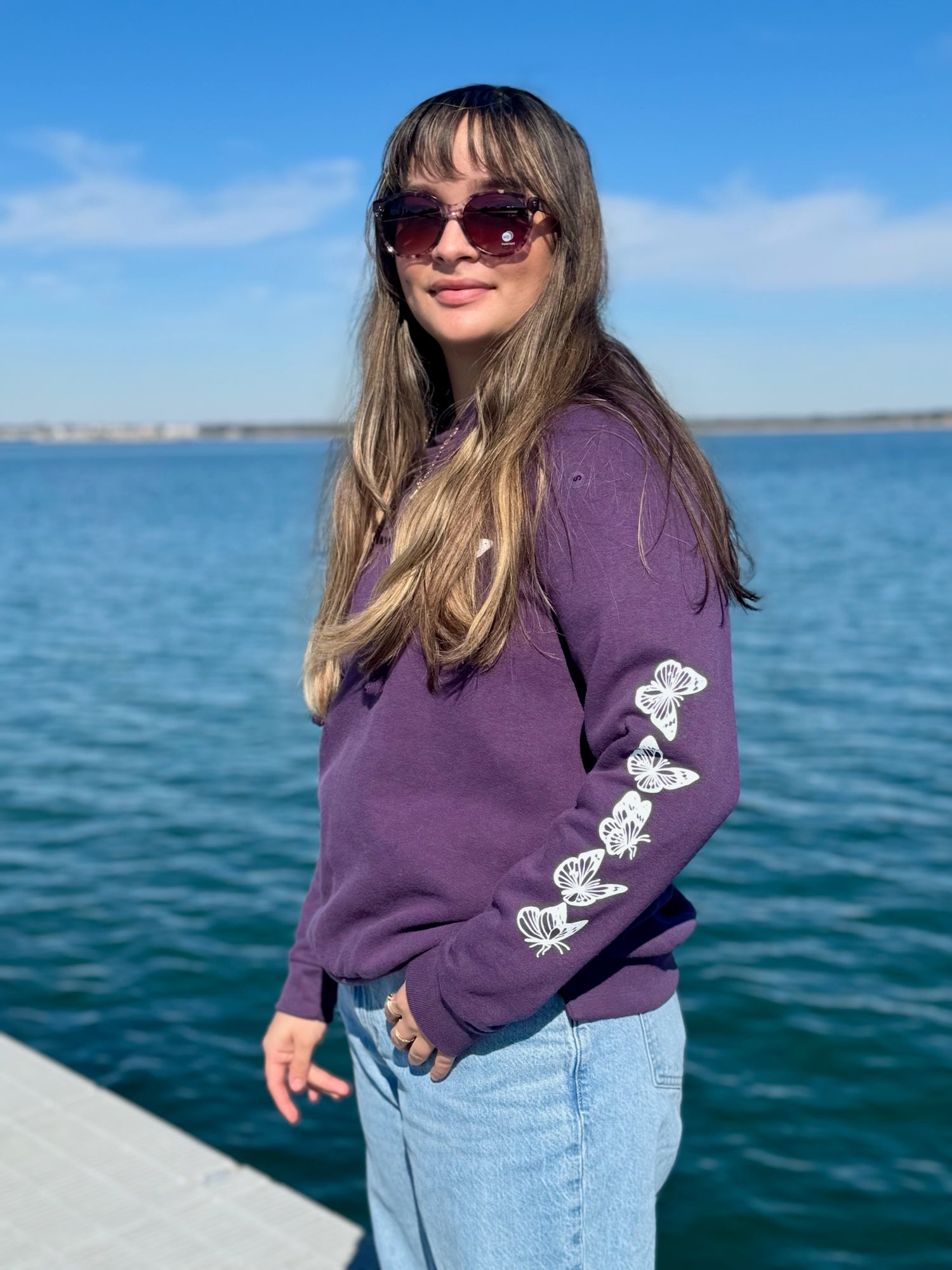 Women’s butterfly pullover hoodie with chest butterfly graphic, butterfly sleeve design, drawstring hood and ribbed trim at Ardor Boutique.