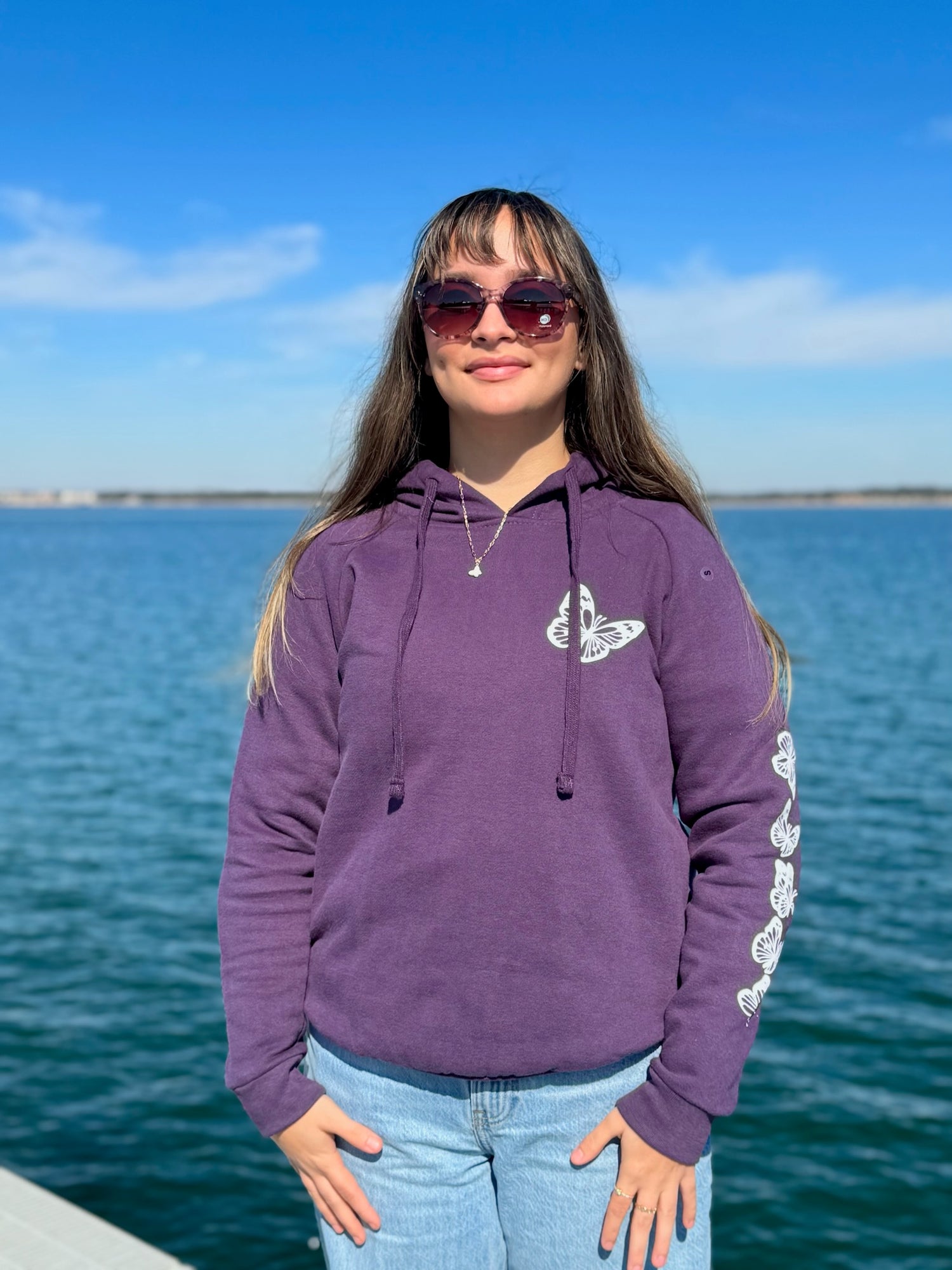 Women’s butterfly pullover hoodie with chest butterfly graphic, butterfly sleeve design, drawstring hood and ribbed trim at Ardor Boutique.