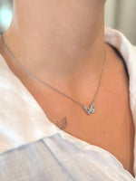 Butterfly necklace worn by a person with a blurred background