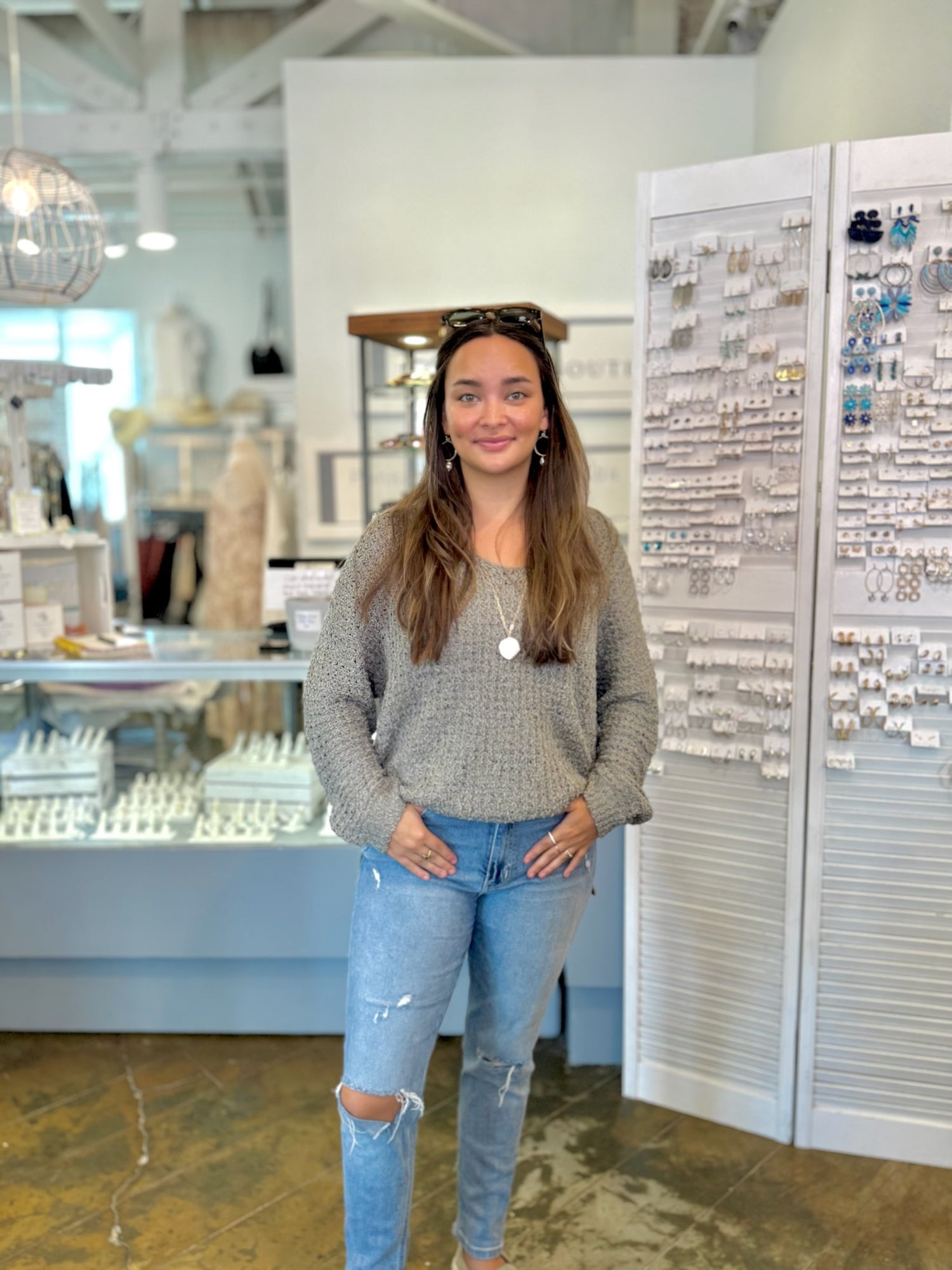 Woman standing in a store with jewelry display cases in the background