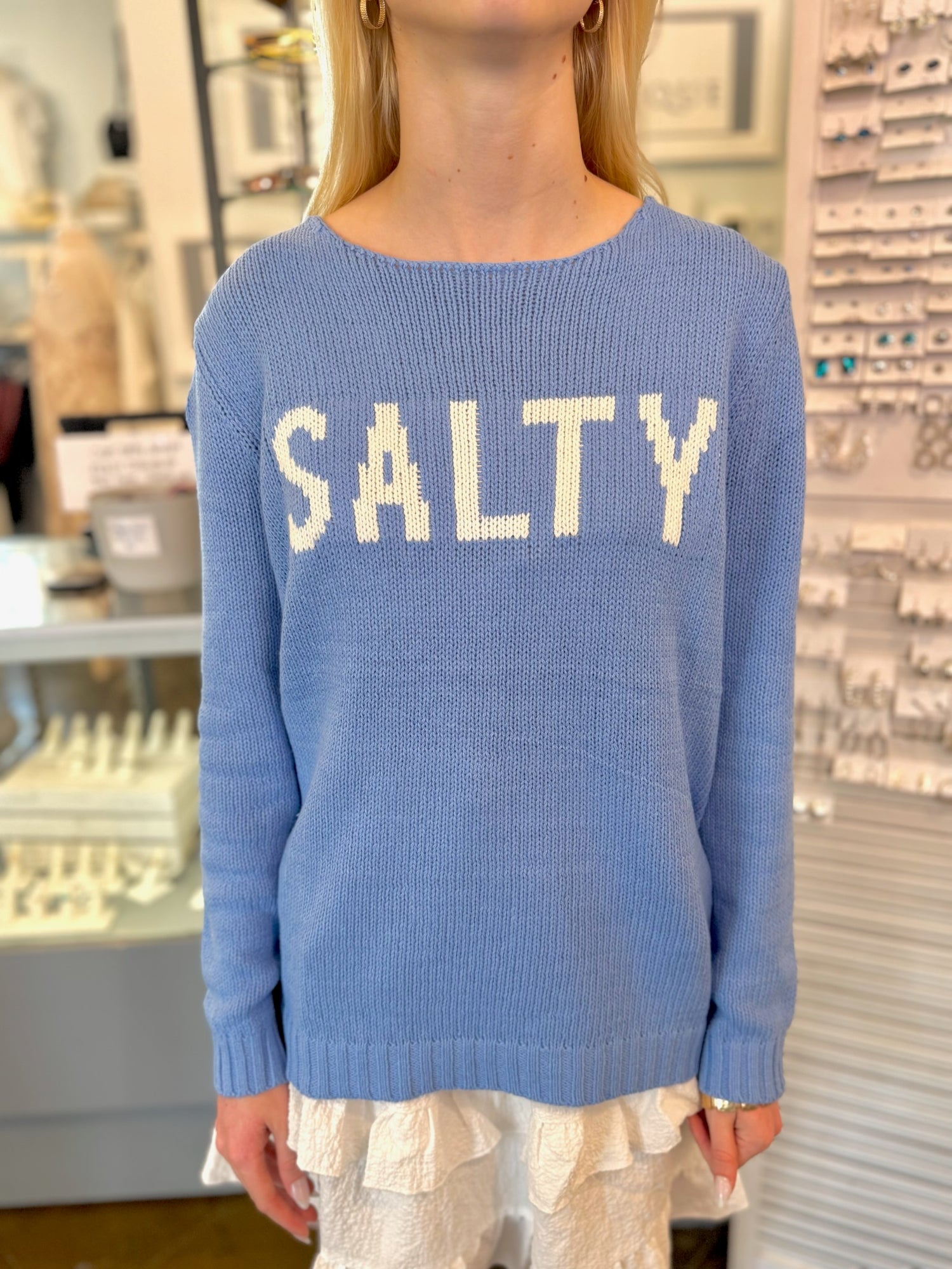 Person wearing a blue sweater with 'SALTY' text 